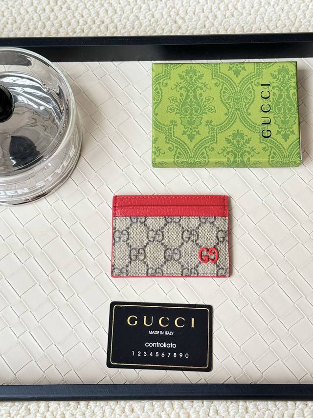 Gucci 卡以充满对比美感的双色调设计令点缀于包身的gg标识风采尽绽面料以黑色gg，内里甄选撞色牛皮制作而成黑色gg Supreme帆布，配深灰色陶瓷效果双g