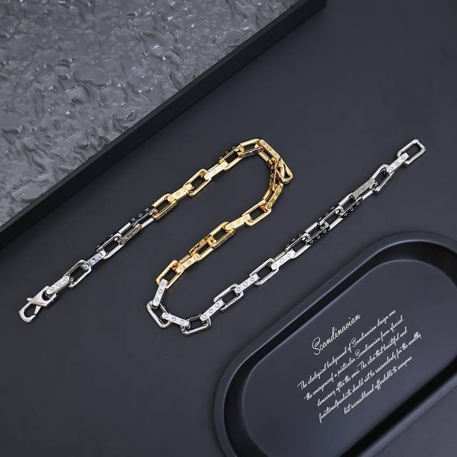 Monogram Chain 项链 本款 Monogramchain 手链拥抱当季华美金属光泽，以非对称色调注入摩登新意。 Monogram 铭纹标识贯穿钩扣和