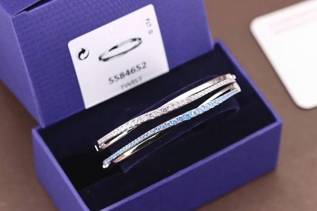 Swarovski 螺旋交错水晶扭纹手镯 双色 这款精致考究的手镯是以现代手法诠释时下流行的螺旋元素，展现含蓄优雅的魅力。手镯上缀有闪亮耀眼的浅蓝色Swarov